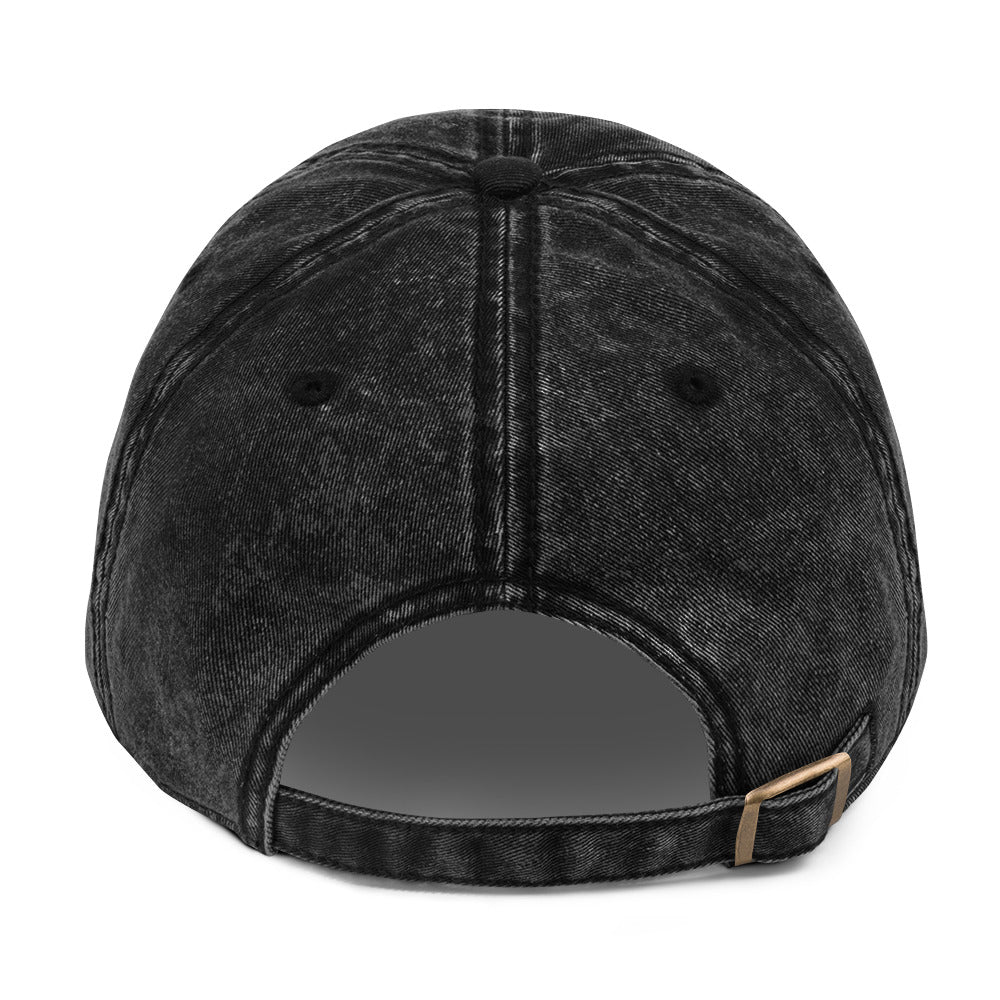 Black denim cap with a strap on a white background