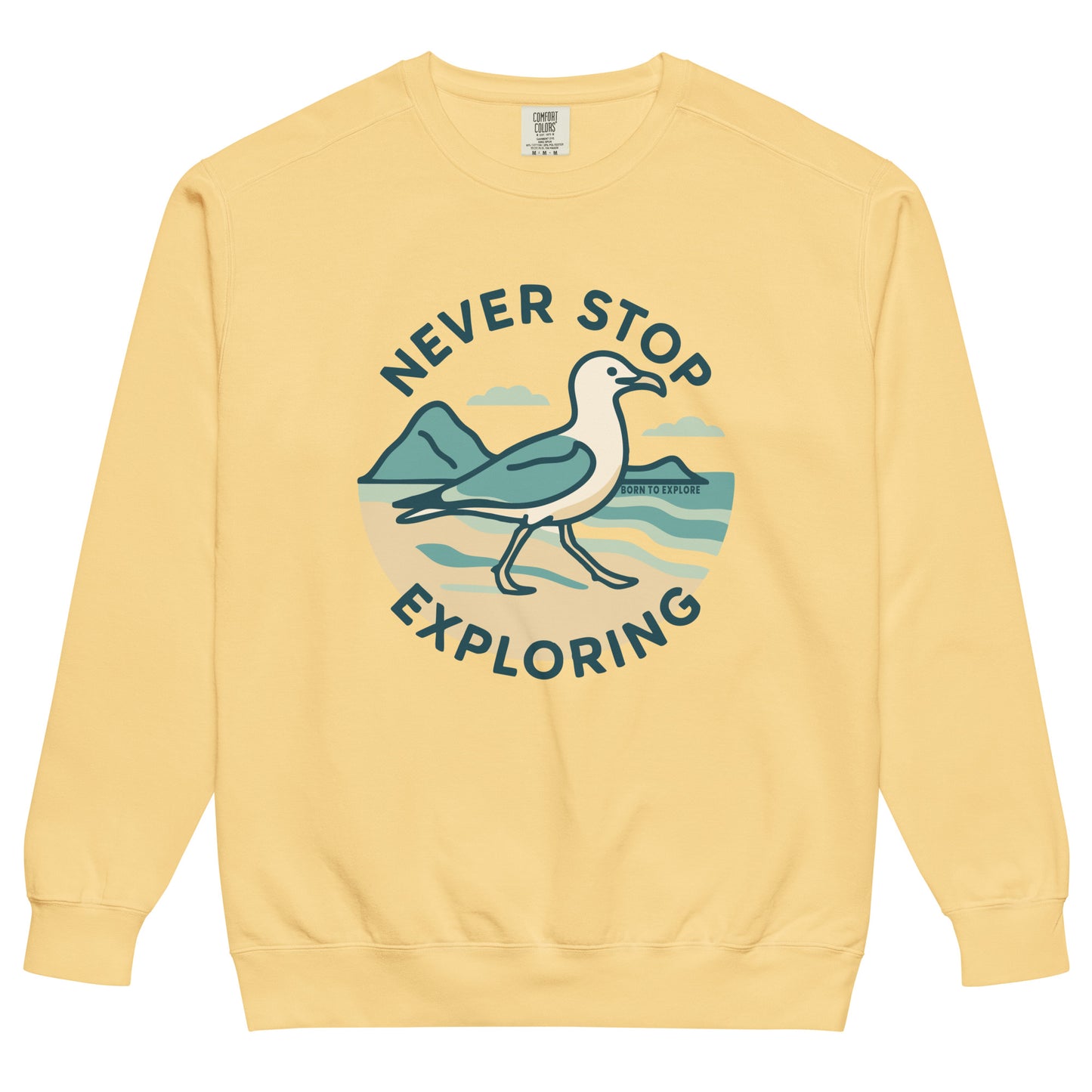 Yellow sweatshirt with a seagull, beach and ocean graphic and 'Never Stop Exploring' text on a white background