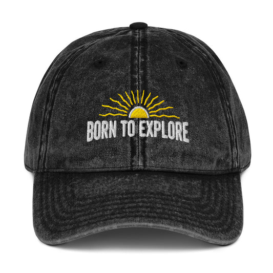 Black denim cap with 'Born to Explore' text and sun graphic on a white background