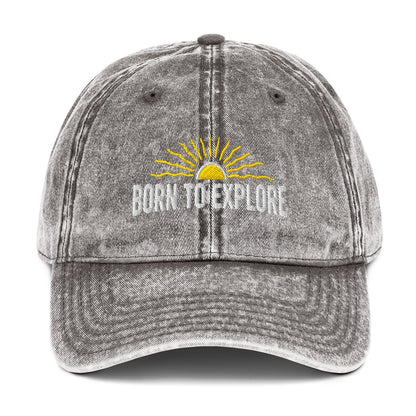 Light gray denim cap with 'Born to Explore' text and sun graphic on a white background